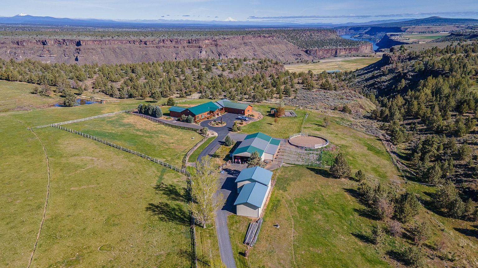 Aerial view of the 118-acre estate on the rim of the Crooked River canyon at 10000 SW Lyons Drive, with pastureland in the foreground and the high-desert plateau beyond